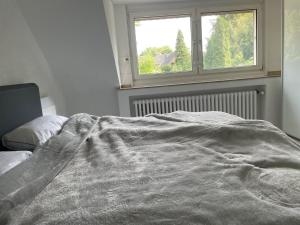 Appartment Königshof في كريفيلد: سرير غير مرتب في غرفة نوم مع نافذة