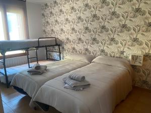 - une chambre avec 2 lits superposés et des serviettes dans l'établissement Apto en Campo Valle de Benasque 2 dormitorios Wifi, à Campo