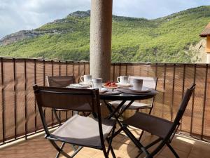 d'une table et de chaises sur un balcon avec vue. dans l'établissement Apto en Campo Valle de Benasque 2 dormitorios Wifi, à Campo