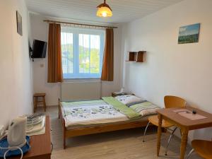 ein kleines Schlafzimmer mit einem Bett und einem Tisch in der Unterkunft Nad Bieszczadzkim Morzem in Polańczyk