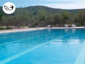 a large swimming pool with blue water at El Pati de L´Oroneta in Els Ibarsos