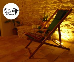 a wooden rocking chair in a room with a stone wall at El Pati de L´Oroneta in Els Ibarsos