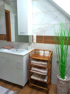 łazienka z umywalką i półką z ręcznikami w obiekcie Polna Zagroda - domek do wynajęcia w Kielcach