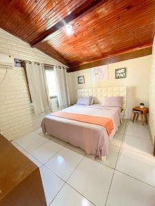 1 dormitorio con cama y techo de madera en Residência Medina - House by La Playa, en Porto de Galinhas