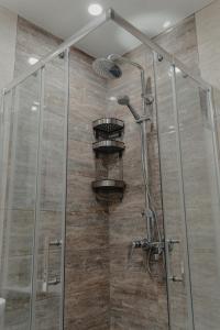 une douche avec une porte vitrée dans l'établissement Hugo, à Varna