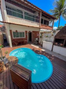 una gran piscina azul en una terraza de madera en Residência Medina - House by La Playa, en Porto de Galinhas