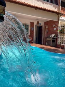 un chapuzón de agua en una piscina en Residência Medina - House by La Playa, en Porto de Galinhas