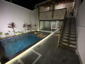 a swimming pool in a house with a staircase at Hospedaria Flamboyant in Goiânia