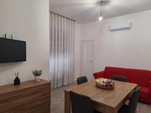 ein Wohnzimmer mit einem Tisch und einem roten Sofa in der Unterkunft Luppolo Amaro in Sommatino