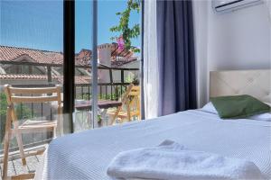 - une chambre avec un lit et une vue sur un balcon dans l'établissement CARETTA PANSİYOn, à Kaş