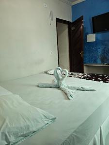 Dos cisnes hechos de toallas en una cama en Pousada Gale Orla, en Maragogi