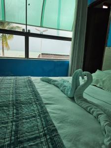 Un dormitorio con una cama con cisnes. en Pousada Gale Orla, en Maragogi