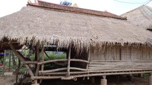 una cabaña con techo de paja encima en OBT - The Longan Bungalow 