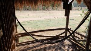 的住宿－OBT - The Longan Bungalow，从带田野的栅栏窗口欣赏美景