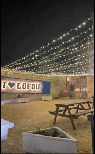 洛夫的住宿－Lofou Maisonette，建筑物顶部带灯的野餐桌