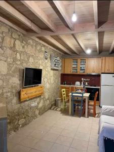 a living room with a tv on a stone wall at Lofou Maisonette in Lofou
