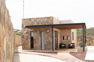 a modern house with a stone wall at Catrina Valle - Ubicación 10 in Valle de Guadalupe