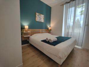 ein Schlafzimmer mit einem großen Bett und einem Fenster in der Unterkunft Appartements à thème in Clermont-Ferrand