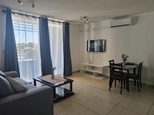 a living room with a couch and a dining room table at City Junction Windhoek in Windhoek