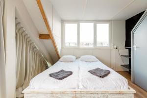 1 dormitorio con 1 cama con 2 toallas en Zon Modern beach house, en Bergen aan Zee