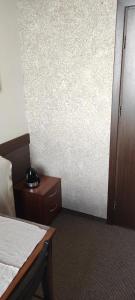 a hotel room with a bed and a nightstand with a alarm clock at Hostel Lux in Kaunas