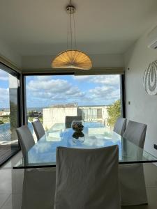 a dining room with a glass table and a large window at Amplio duplex al mar en manantiales in Punta del Este