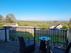 a balcony with chairs and a table and a view at No.11 in Llannon