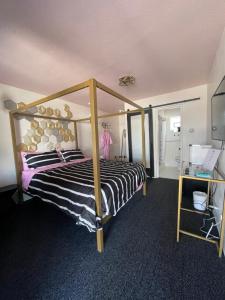 Rainbow Motel في غريلي: غرفة نوم بسرير مع مظلة خشبية