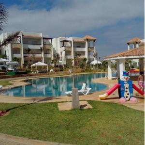 a resort swimming pool with a slide and a water park at Bel Appart Marina Golf Asilah in Asilah