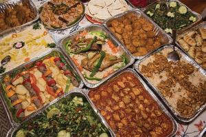 uma mesa com muitas bandejas de diferentes tipos de alimentos em Samira House em Amã