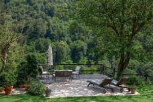 a patio with a table and chairs and a tree at ghigorotto, suite&villa in Benevello +22 photos