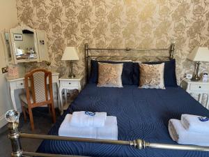 a bedroom with a blue bed with towels on it at Dionard Guest House in Inverness