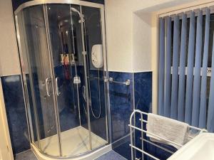 a shower with a glass door in a bathroom at Dionard Guest House in Inverness