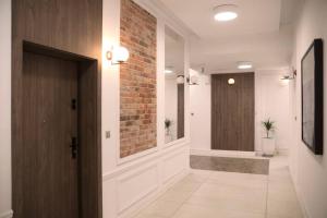 a hallway with a door and a brick wall at Elegant Apartment in the City Center in Wrocław