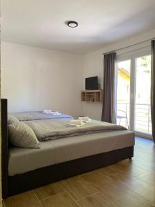 a bedroom with a large bed with a window at Apartmani Braća Kovačević in Foča