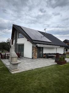 a house with a solar roof and a patio at Chalet Dream High Tatras in Stará Lesná