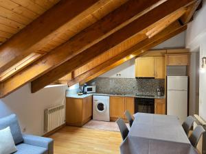 a kitchen with wooden cabinets and a table and chairs at Casa La Muga in Benasque +13 photos