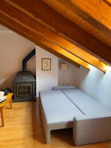 a bedroom with a bed and a wood stove at Casa La Muga in Benasque
