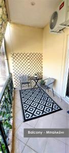 un patio con 2 sillas y una mesa sobre una alfombra en Efi Studio 4 Lamia en Lamía