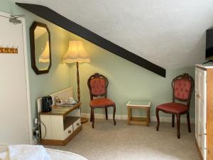 1 dormitorio con 2 sillas, mesa y lámpara en The Captain's Lodge Room Only accommodation, en Whitby