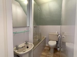 Un baño con inodoro, lavabo y ducha. en The Captain's Lodge Room Only accommodation, en Whitby