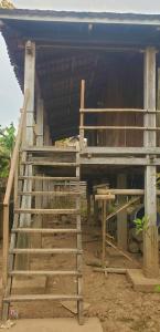 una casa siendo construida con una escalera delante de ella en OBT - The Mango Bungalow 
