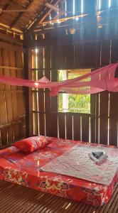 un letto in una camera con nastro rosa di OBT - The Mango Bungalow 