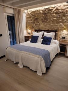 1 dormitorio con 1 cama grande con almohadas azules en Casa Rural Garabitero, en Laguardia