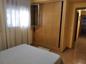 a bedroom with a bed and a cabinet with a television at Marvel apartamento Vinaros in Vinaròs