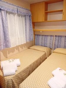 two beds in a small room with towels on them at B&B Helga's Agricampeggio in Seùlo +62 photos