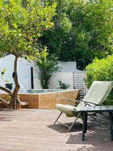 eine Terrasse mit einem Stuhl und einer Badewanne in der Unterkunft Casa do Mar - Golf Jamor in Oeiras