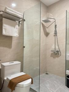 uma casa de banho com um WC e uma cabina de duche em vidro. em MARIS HOTEL SẦM SƠN em Sam Son