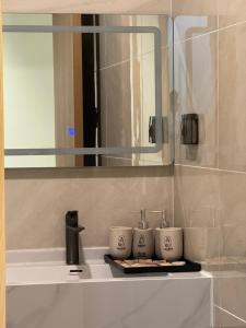um lavatório de casa de banho com três chávenas numa bandeja em MARIS HOTEL SẦM SƠN em Sam Son