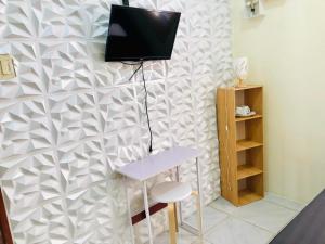 Zimmer mit einem Tisch und einem TV an der Wand in der Unterkunft Wakim’s INN in Coron